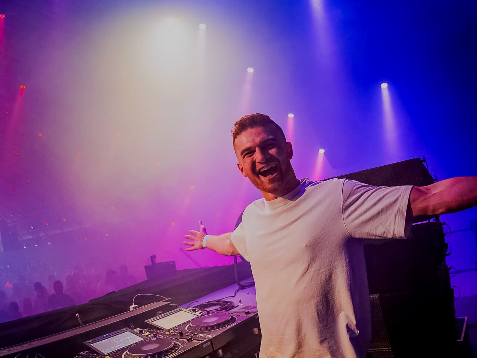 A-RIZE arms spread behind the decks